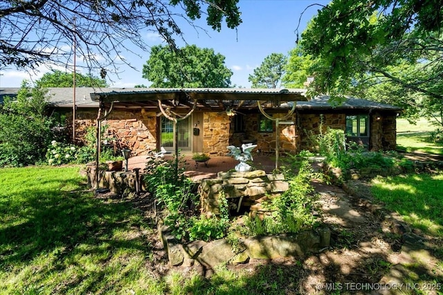 1943 W 163rd St, Skiatook, OK 74070 - rear view of house featuring stone siding, a patio area, and a yard