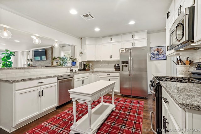 1628 E 45th Pl, Tulsa, OK 74105 - kitchen featuring appliances with stainless steel finishes, a peninsula, tasteful backsplash, dark wood finished floors, and recessed lighting