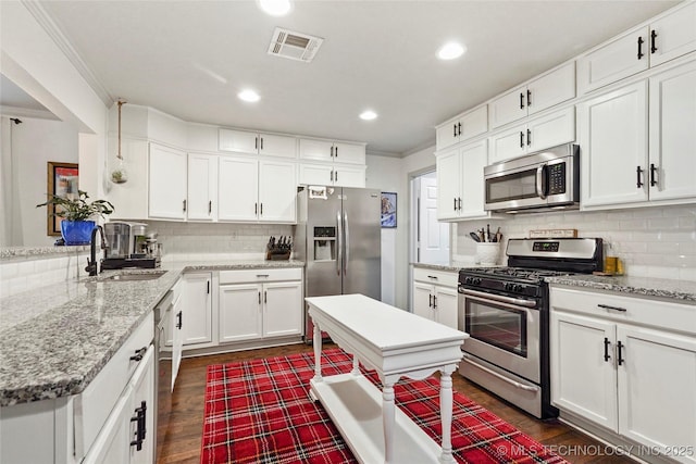 1628 E 45th Pl, Tulsa, OK 74105 - kitchen with appliances with stainless steel finishes, tasteful backsplash, white cabinetry, dark wood-style floors, and recessed lighting