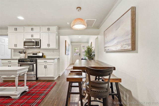 1628 E 45th Pl, Tulsa, OK 74105 - kitchen with stainless steel appliances, ornamental molding, white cabinets, decorative backsplash, and dark wood-style flooring