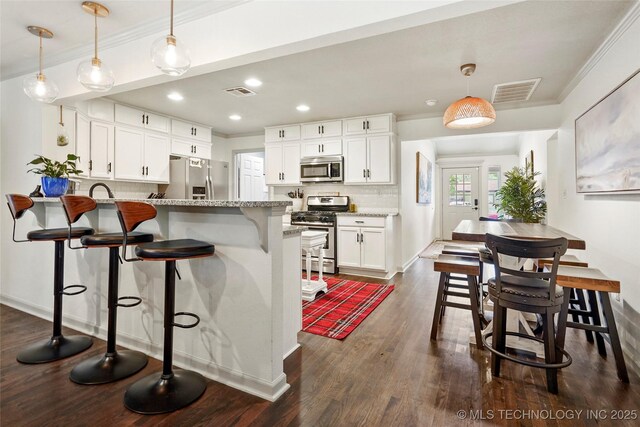 1628 E 45th Pl, Tulsa, OK 74105 - kitchen featuring appliances with stainless steel finishes, ornamental molding, a peninsula, backsplash, and white cabinets