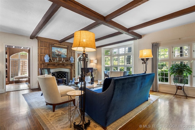 1249 E 26th St, Tulsa, OK 74114 - living room featuring beam ceiling, wood finished floors, a fireplace, and a textured ceiling