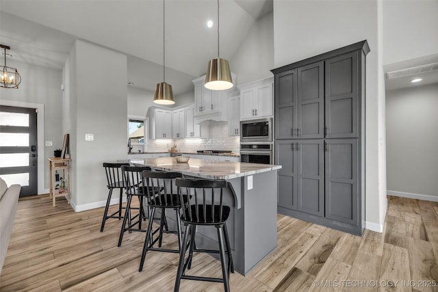 25133 Shade Tree Pl, Claremore, OK 74019 - kitchen featuring built in microwave, high vaulted ceiling, oven, a kitchen island, and decorative backsplash
