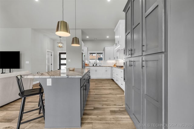 25133 Shade Tree Pl, Claremore, OK 74019 - kitchen featuring a center island, stainless steel refrigerator, open floor plan, light wood-style flooring, and recessed lighting