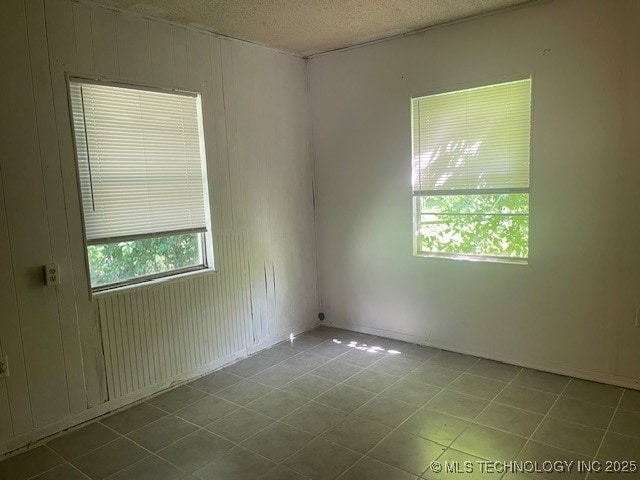 720 B NE, Ardmore, OK 73401 - spare room featuring tile patterned flooring and a textured ceiling
