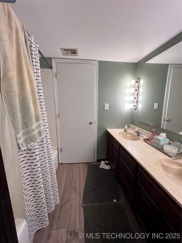 13226 N 91st Ave E, Collinsville, OK 74021 - bathroom featuring wood finished floors, double vanity, and shower / bath combination with curtain