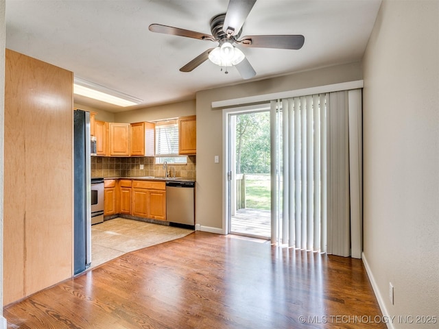 4654 E 68th St S Unit 199, Tulsa, OK 74136 - kitchen with appliances with stainless steel finishes, decorative backsplash, ceiling fan, and light wood finished floors