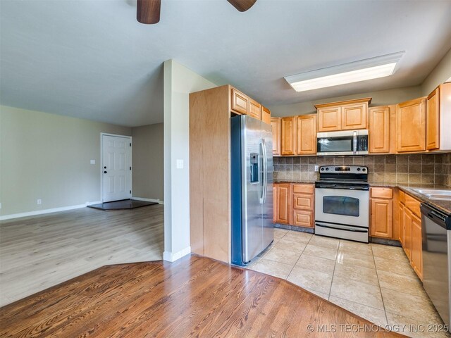 4654 E 68th St S Unit 199, Tulsa, OK 74136 - kitchen featuring appliances with stainless steel finishes, tasteful backsplash, light wood-type flooring, and ceiling fan