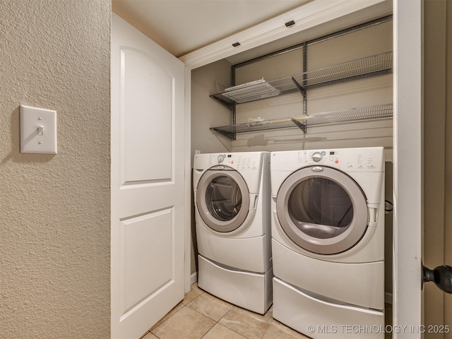 4654 E 68th St S Unit 199, Tulsa, OK 74136 - laundry room with light tile patterned floors, washer and clothes dryer, and a textured wall