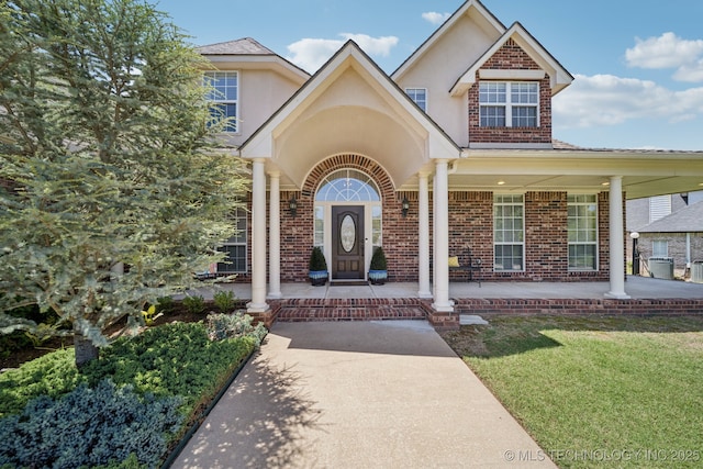 13614 W 42nd Pl, Sand Springs, OK 74063 - property entrance featuring brick siding, covered porch, a lawn, and stucco siding
