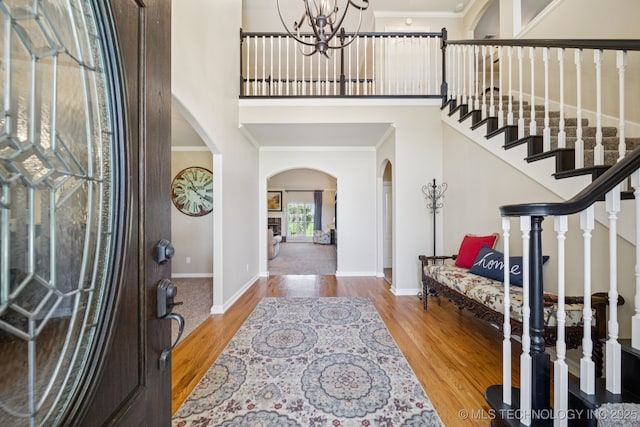 13614 W 42nd Pl, Sand Springs, OK 74063 - foyer featuring arched walkways, crown molding, a high ceiling, a chandelier, and wood finished floors