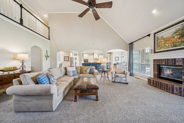 13614 W 42nd Pl, Sand Springs, OK 74063 - living room with arched walkways, ceiling fan, carpet flooring, high vaulted ceiling, and a fireplace