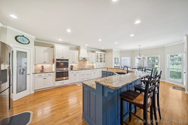 13614 W 42nd Pl, Sand Springs, OK 74063 - kitchen featuring appliances with stainless steel finishes, ornamental molding, a kitchen bar, white cabinetry, and decorative backsplash