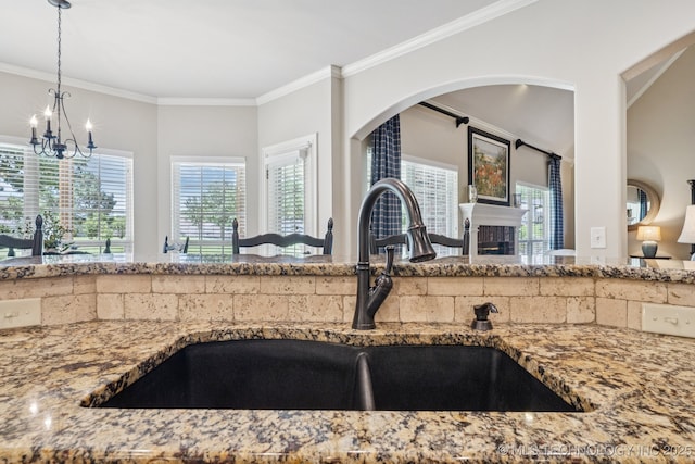 13614 W 42nd Pl, Sand Springs, OK 74063 - kitchen with light stone counters, crown molding, a chandelier, decorative light fixtures, and a fireplace