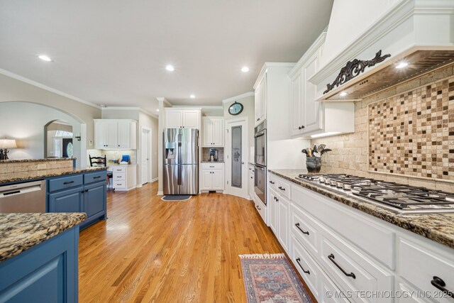 13614 W 42nd Pl, Sand Springs, OK 74063 - kitchen with blue cabinets, stainless steel appliances, white cabinets, crown molding, and tasteful backsplash