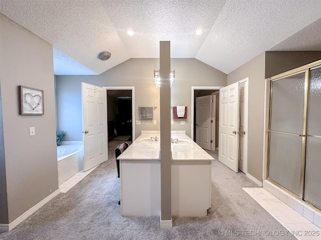 7515 S 108th E Ave, Tulsa, OK 74133 - full bathroom featuring a bath, vaulted ceiling, a textured ceiling, a shower stall, and double vanity