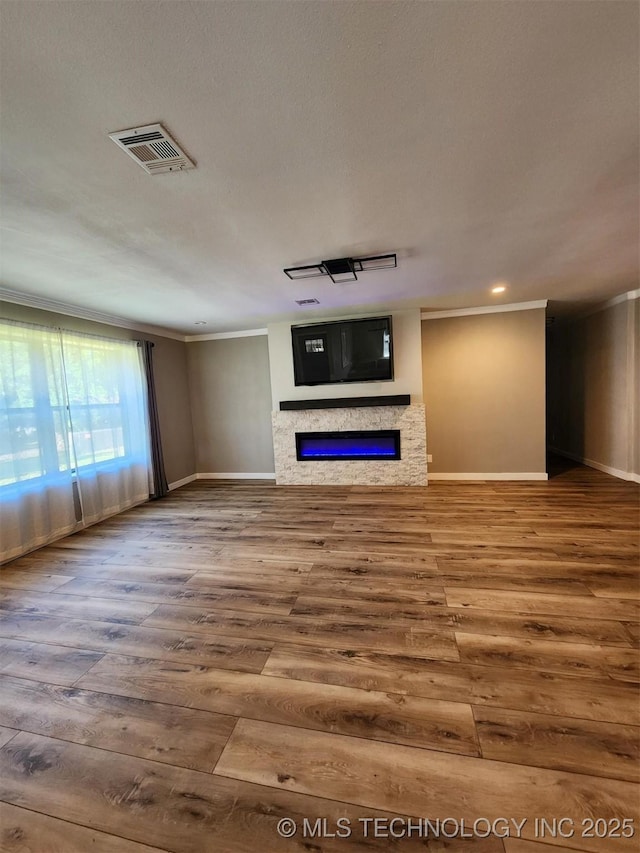 72078 S 321st Rd, Wagoner, OK 74467 - unfurnished living room with ornamental molding, a glass covered fireplace, wood finished floors, and recessed lighting