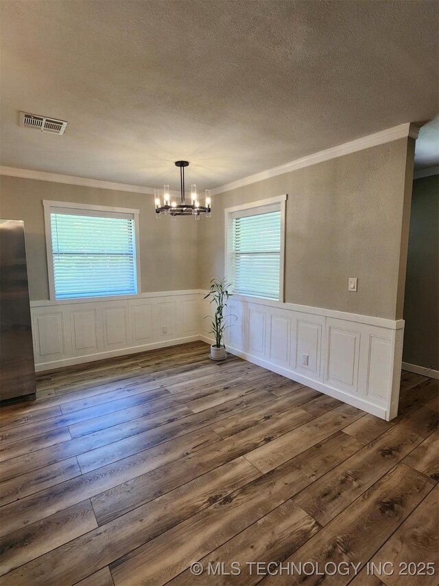 72078 S 321st Rd, Wagoner, OK 74467 - unfurnished dining area with ornamental molding, hardwood / wood-style flooring, a chandelier, a textured ceiling, and healthy amount of natural light