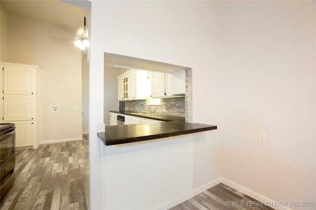 416434 Lakeside, Checotah, OK 74426 - kitchen with dark countertops, light wood-style flooring, tasteful backsplash, and white cabinetry