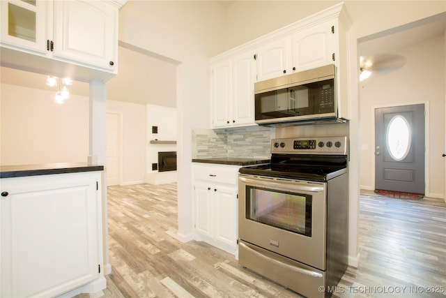 416434 Lakeside, Checotah, OK 74426 - kitchen with stainless steel appliances, light wood-style floors, dark countertops, and decorative backsplash