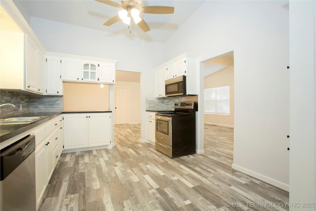 416434 Lakeside, Checotah, OK 74426 - kitchen with appliances with stainless steel finishes, decorative backsplash, dark countertops, a ceiling fan, and light wood finished floors