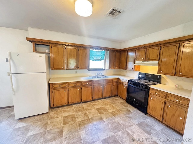 17564 W Grandview Dr, Tahlequah, OK 74464 - kitchen with black range with gas cooktop, freestanding refrigerator, under cabinet range hood, and brown cabinets