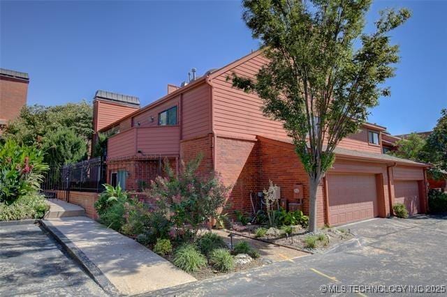 30 E Woodward Blvd S Unit 24, Tulsa, OK 74114 - view of home's exterior with brick siding and a chimney