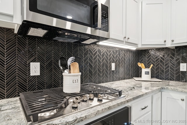 7705 S 232nd E Ave, Broken Arrow, OK 74014 - kitchen with stainless steel appliances, white cabinetry, tasteful backsplash, and light stone countertops