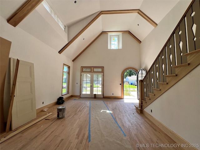 4954 S Boston Pl, Tulsa, OK 74105 - unfurnished living room with high vaulted ceiling, wood finished floors, stairs, and french doors