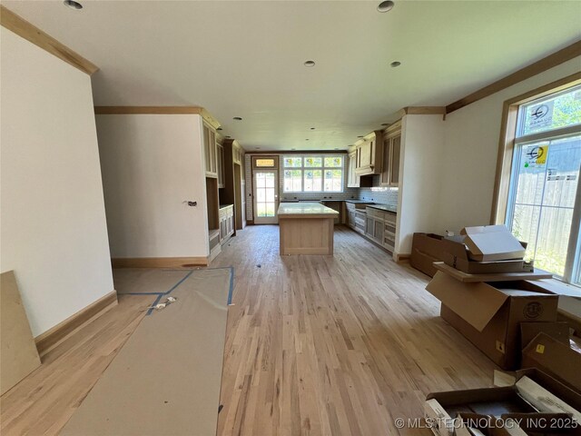 4954 S Boston Pl, Tulsa, OK 74105 - kitchen with a kitchen island, light wood finished floors, backsplash, and light countertops