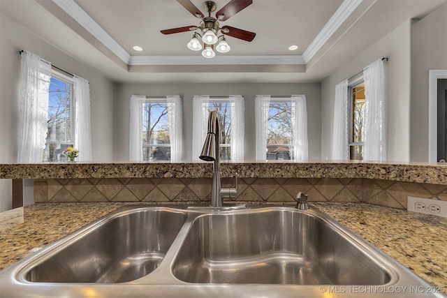 12916 E 181st St S, Bixby, OK 74008 - kitchen view of ceiling fan, ornamental molding, a raised ceiling, light stone counters, and tasteful backsplash