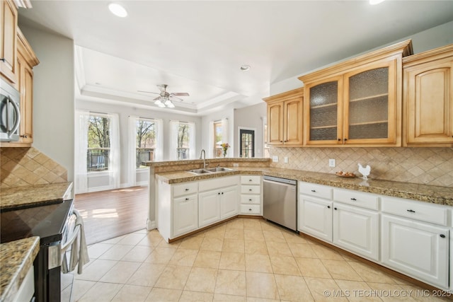 12916 E 181st St S, Bixby, OK 74008 - kitchen with appliances with stainless steel finishes, a peninsula, tasteful backsplash, recessed lighting, and glass insert cabinets