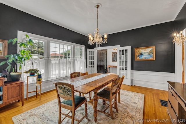1006 E 17th Pl, Tulsa, OK 74120 - dining space featuring a chandelier, french doors, and light wood-style floors