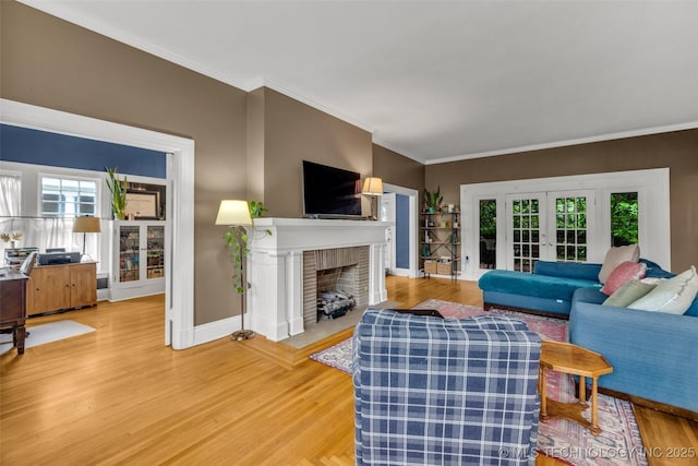 1006 E 17th Pl, Tulsa, OK 74120 - living area featuring french doors, light wood finished floors, plenty of natural light, ornamental molding, and a fireplace