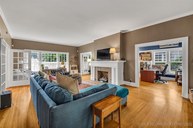 1006 E 17th Pl, Tulsa, OK 74120 - living room featuring a fireplace, crown molding, light wood-style flooring, an office area, and french doors
