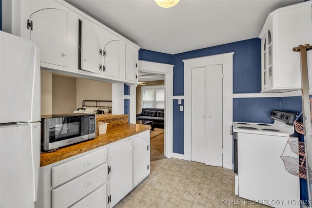 1006 E 17th Pl, Tulsa, OK 74120 - kitchen featuring white appliances, white cabinets, a ceiling fan, and light flooring