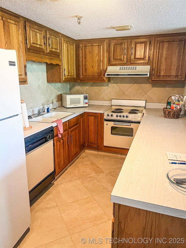 56701 E 310th Rd Unit 712, Afton, OK 74331 - kitchen with white appliances, ventilation hood, light countertops, backsplash, and a textured ceiling