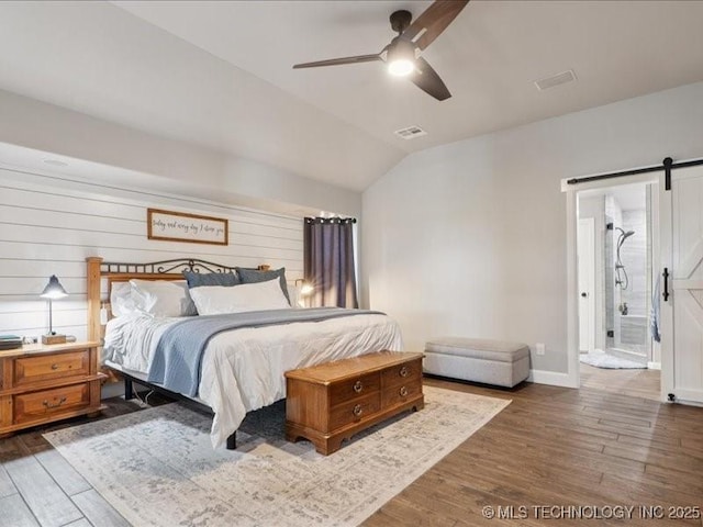 4270 S 4110th Rd, Talala, OK 74080 - bedroom featuring a barn door, wood finished floors, lofted ceiling, ceiling fan, and ensuite bath