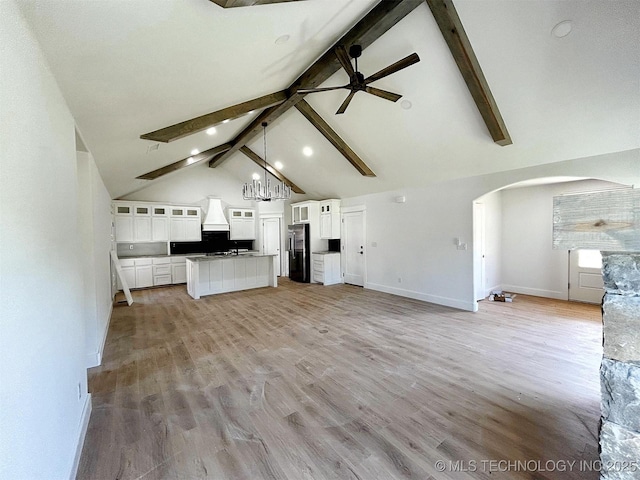 2005 N Alora Ave, Tahlequah, OK 74464 - unfurnished living room featuring arched walkways, beam ceiling, ceiling fan, high vaulted ceiling, and light wood-style flooring