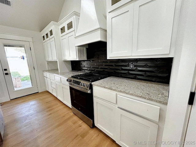 2005 N Alora Ave, Tahlequah, OK 74464 - kitchen with custom range hood, stainless steel gas range oven, tasteful backsplash, white cabinetry, and light wood-style floors