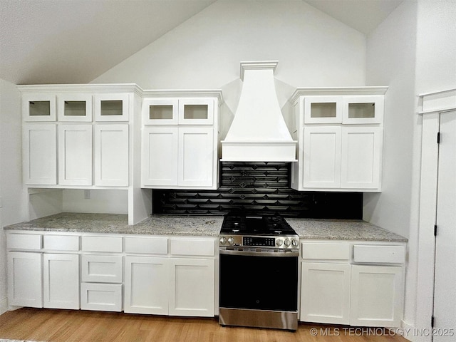 2005 N Alora Ave, Tahlequah, OK 74464 - kitchen with stainless steel stove, premium range hood, lofted ceiling, white cabinets, and decorative backsplash