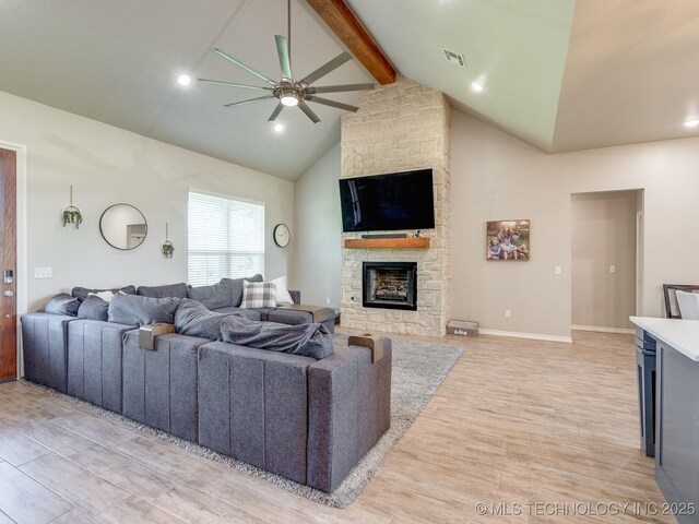 12349 County Road 3571, Ada, OK 74820 - living room with light wood-style floors, a ceiling fan, beam ceiling, a stone fireplace, and high vaulted ceiling