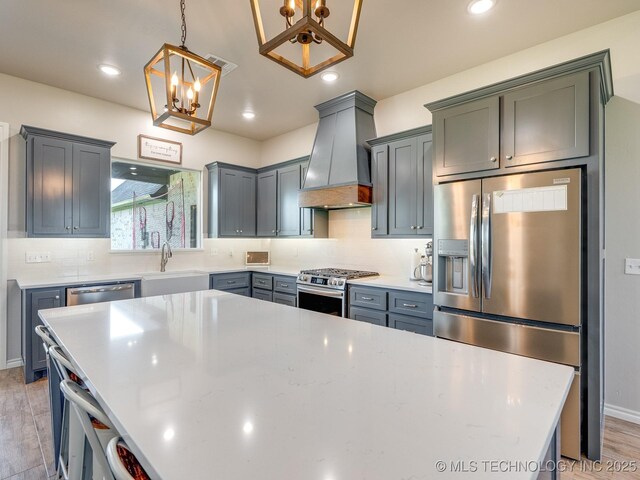 12349 County Road 3571, Ada, OK 74820 - kitchen with appliances with stainless steel finishes, a chandelier, custom range hood, tasteful backsplash, and pendant lighting