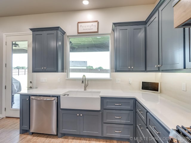 12349 County Road 3571, Ada, OK 74820 - kitchen featuring stainless steel dishwasher, light countertops, tasteful backsplash, light wood finished floors, and gray cabinets