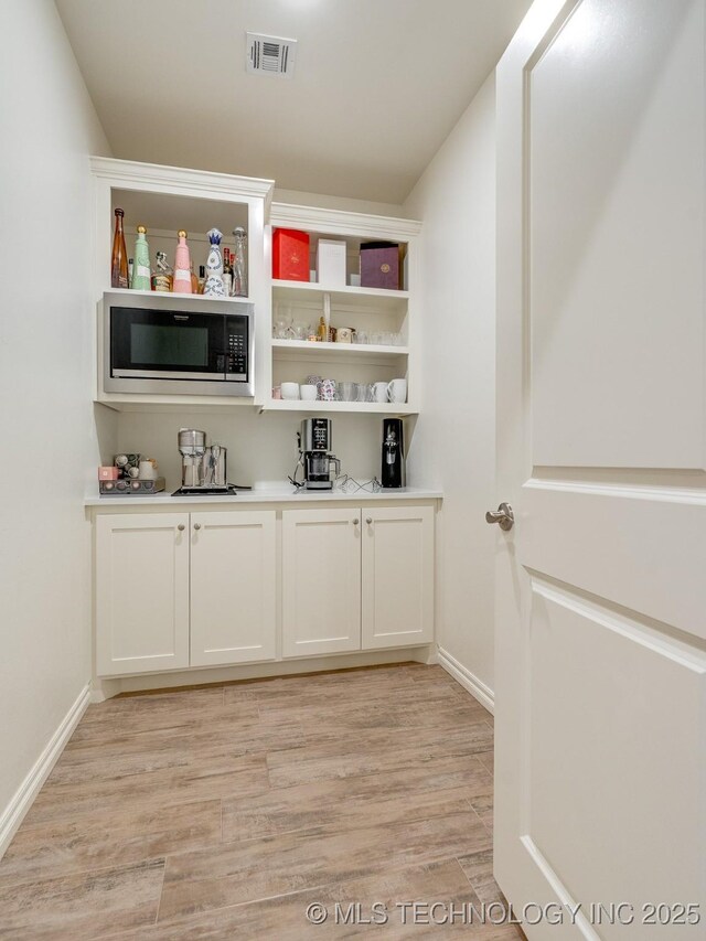 12349 County Road 3571, Ada, OK 74820 - indoor dry bar with built in microwave and light wood-type flooring