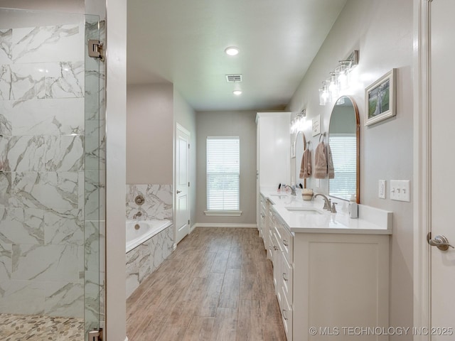 12349 County Road 3571, Ada, OK 74820 - bathroom featuring a bath, a marble finish shower, double vanity, wood finished floors, and recessed lighting