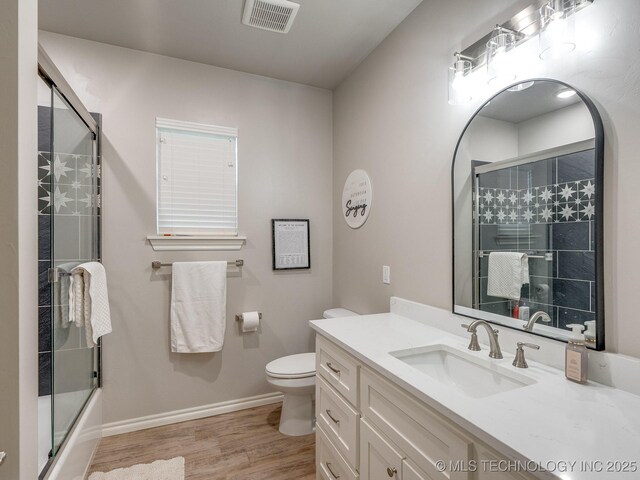 12349 County Road 3571, Ada, OK 74820 - full bath featuring wood finished floors, vanity, and bath / shower combo with glass door