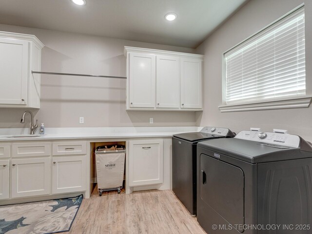12349 County Road 3571, Ada, OK 74820 - washroom featuring separate washer and dryer, cabinet space, light wood-style flooring, and recessed lighting