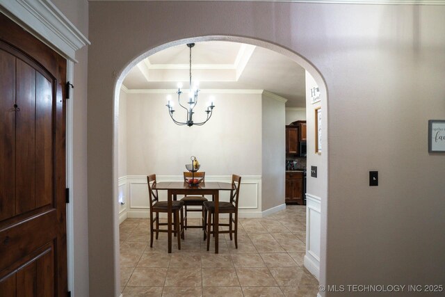 12901 N 124th E Pl, Collinsville, OK 74021 - dining room with arched walkways, a chandelier, ornamental molding, light tile patterned floors, and a raised ceiling