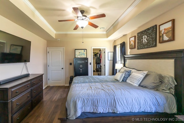 12901 N 124th E Pl, Collinsville, OK 74021 - bedroom featuring a tray ceiling, dark wood-style flooring, crown molding, a spacious closet, and a closet